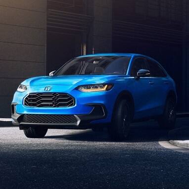 2027 Honda HR-V Sport in Boost Blue Pearl three quarter view maneuvering through the city (Subcompact Crossover SUV).